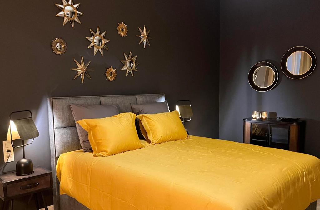 蒙斯Le Vieux Cèdre Grand Place的卧室配有一张黄色的床,墙上挂着星星