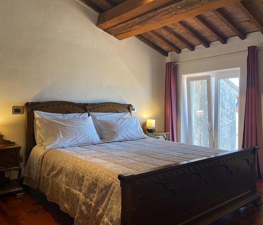 利沃诺TUSCANY LOFT IN THE CITY的卧室配有带白色枕头的床和窗户。
