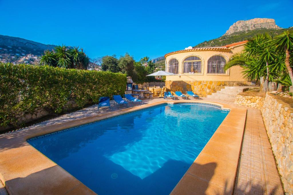 拉坎努塔Villa Sanlio - PlusHolidays的一个带椅子的游泳池以及一座房子