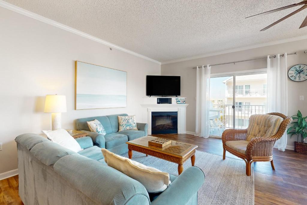 大洋城Whispering Sands 301的客厅设有蓝色的沙发和壁炉