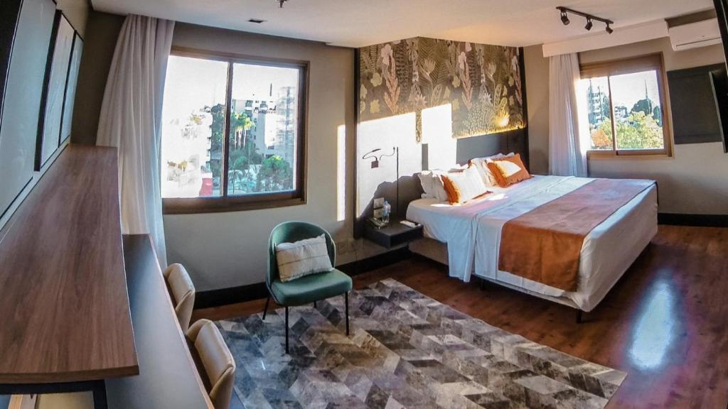 阿雷格里港Art Hotel Transamerica Collection的一间卧室配有一张床、一把椅子和窗户。