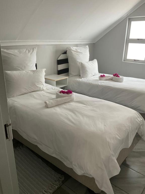 卡蒂马穆利洛Riverside Lodge的两张带白色床单和粉红色鲜花的床