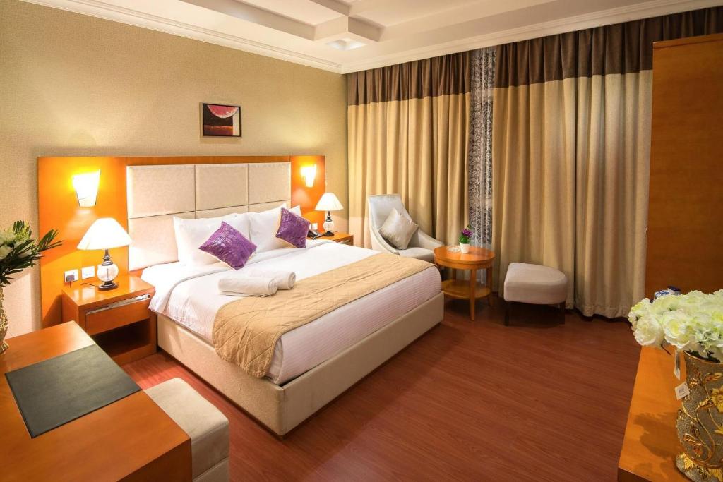 新德里Jupiter Plaza Delhi Airport的酒店客房带一张大床和一把椅子