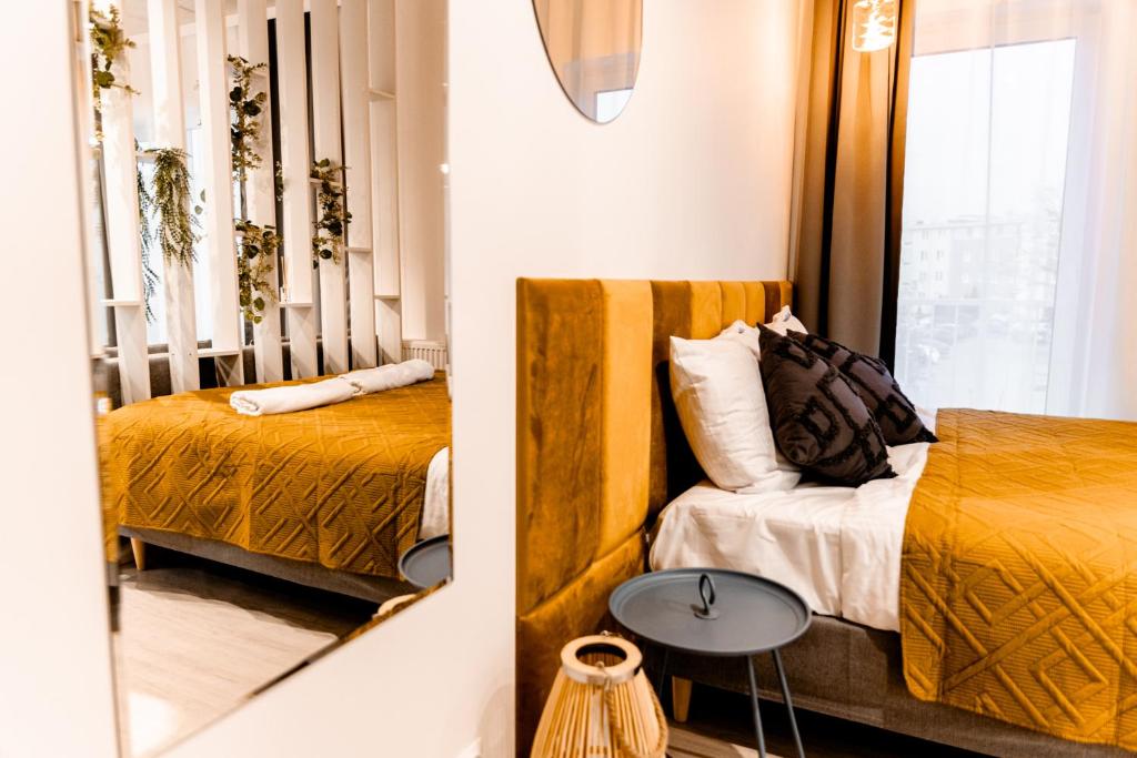 戈莱纽夫Hop & Lulu Premium Apartments的一间卧室设有两张床、一张桌子和一个窗口
