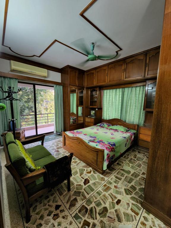 达卡Dhanmondi Furnished Lake View Apartment的一间卧室配有一张床、一张沙发和一把椅子