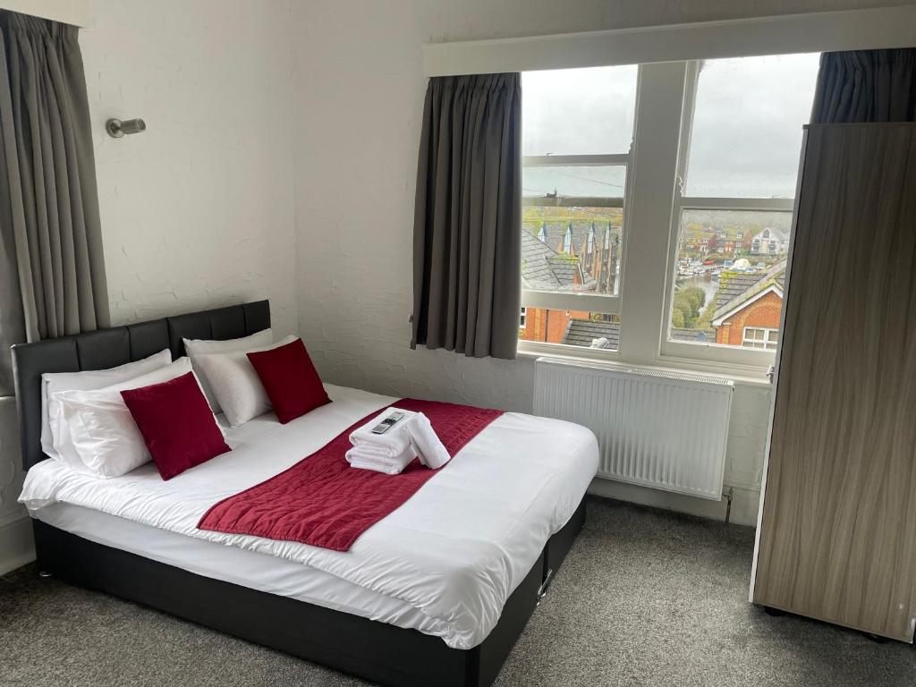 南安普敦River side rooms的一间卧室配有一张带红色枕头的床和一扇窗户
