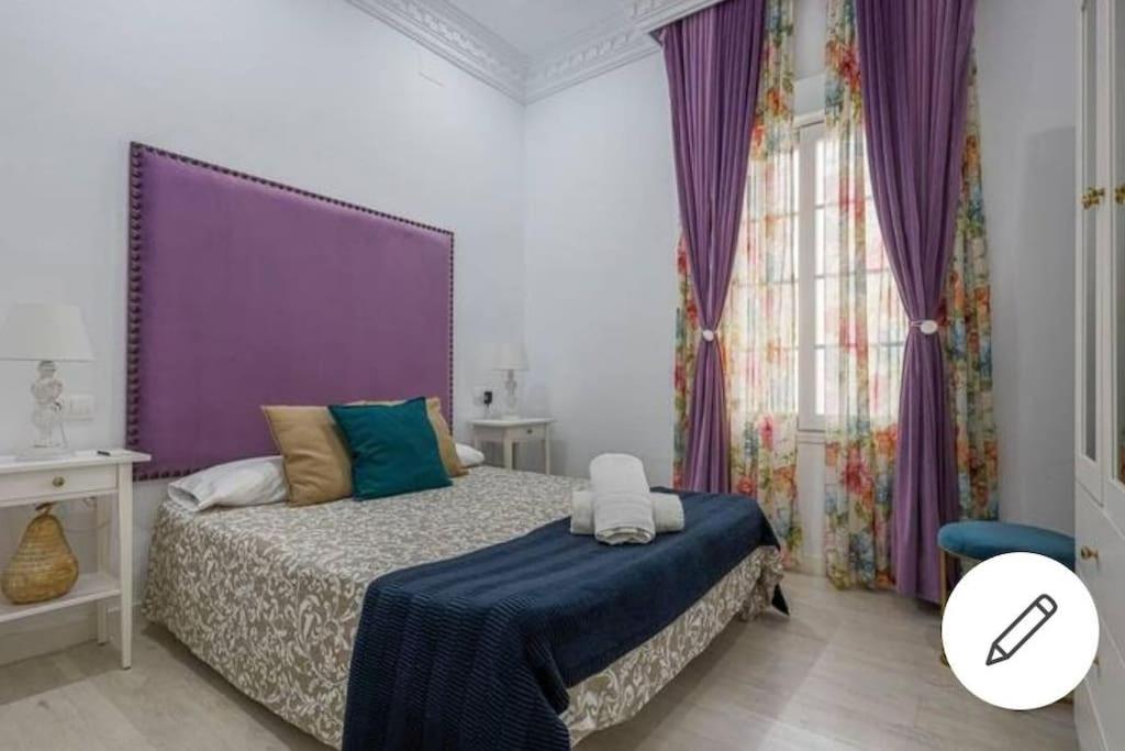 塞维利亚Fernando IV 29A的一间卧室配有一张带紫色床头板的床