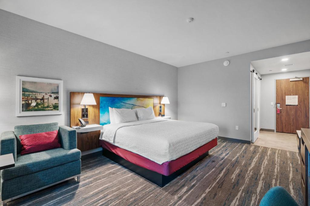 莫罗贝Hampton Inn Morro Bay的配有一张床和一把椅子的酒店客房