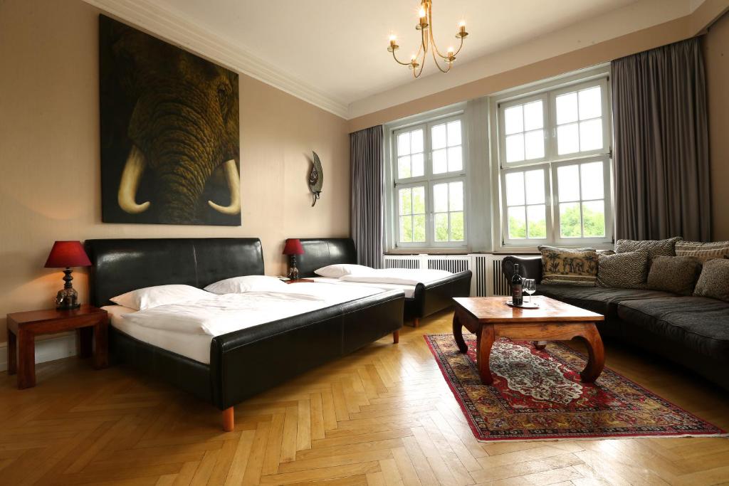 汉堡阿姆斯特丹酒店的一间带两张床和一张沙发的客厅