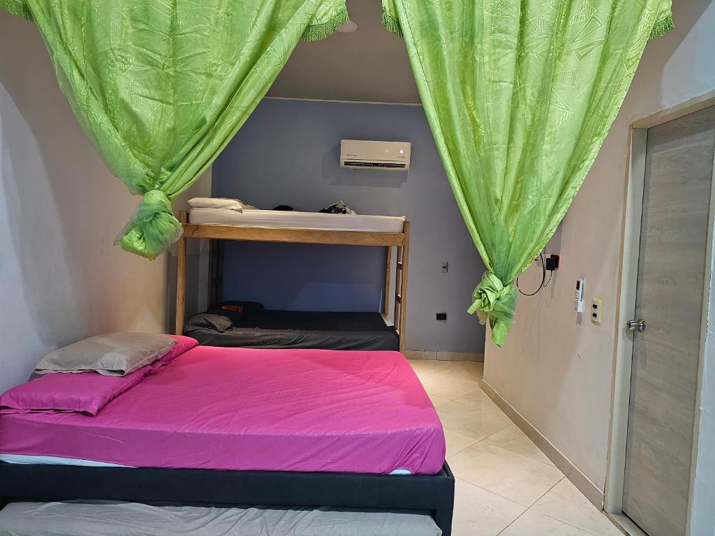 内科克利Brisa Marina Apartaestudios的一间卧室配有一张带粉红色床单的双层床