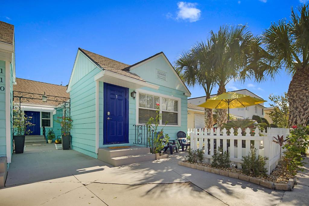 沃思湖Steps to Beach & Downtown! Cozy Beach Bungalow #3的蓝色的房子,有蓝色的门和白色的栅栏