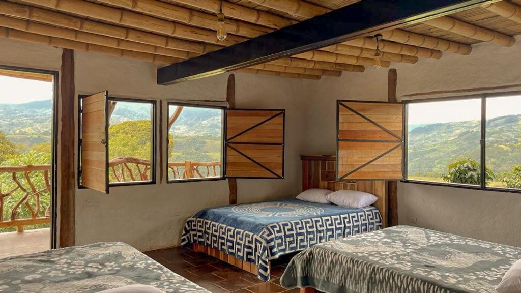 圣奥古斯丁Hotel Rancho Maju的一间卧室设有两张床和美景窗户。