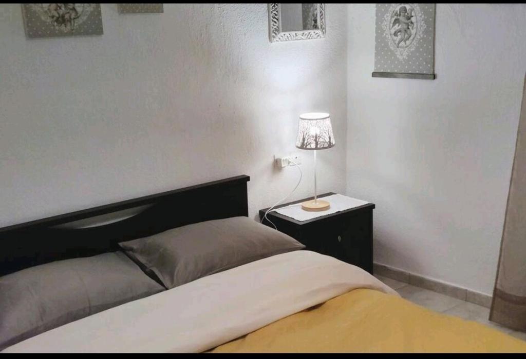 Evaggelia's Apartments 3 Διαμονή στο χωριό的一间卧室配有一张床,床头柜上配有一盏灯