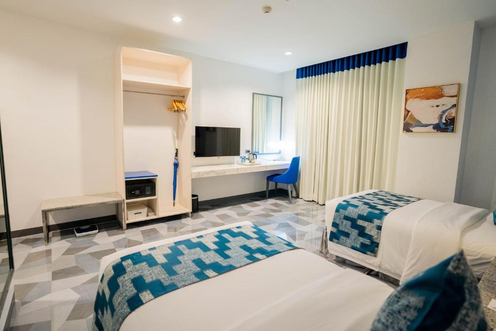 宿务Stacia Hotel powered by Cocotel的酒店客房设有两张床和电视。