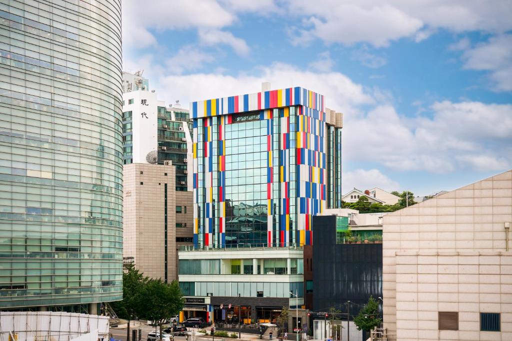 首尔Imperial Palace Boutique Hotel Itaewon的一座高大的建筑,外墙色彩缤纷,位于城市