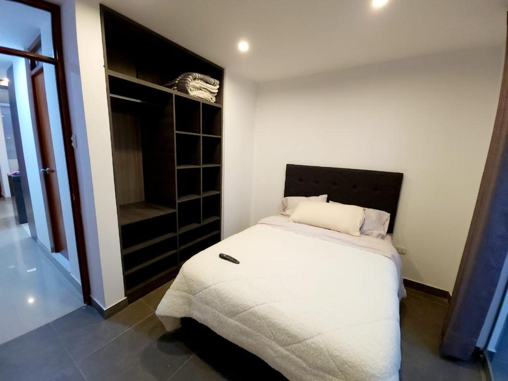 伊察Acogedor departamento en Huacachina的卧室配有白色的床和衣柜。