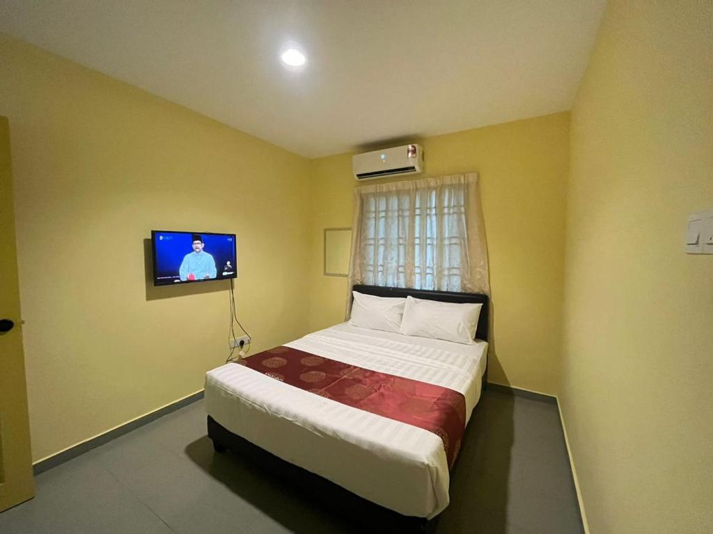 新山Rahmah Sojourn Center的卧室配有一张床铺,墙上配有电视