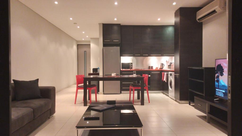 温特和克Business Pro Apartment, Windhoek的客厅配有沙发和桌子