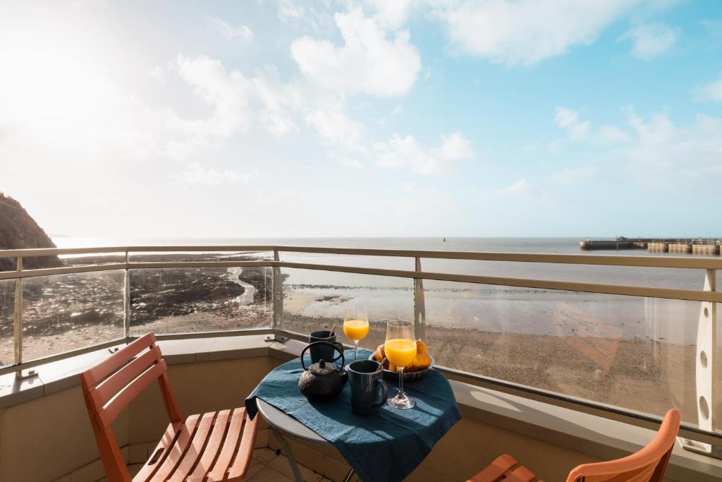 格朗维尔Front de mer vue exceptionnelle的海景阳台上的桌子