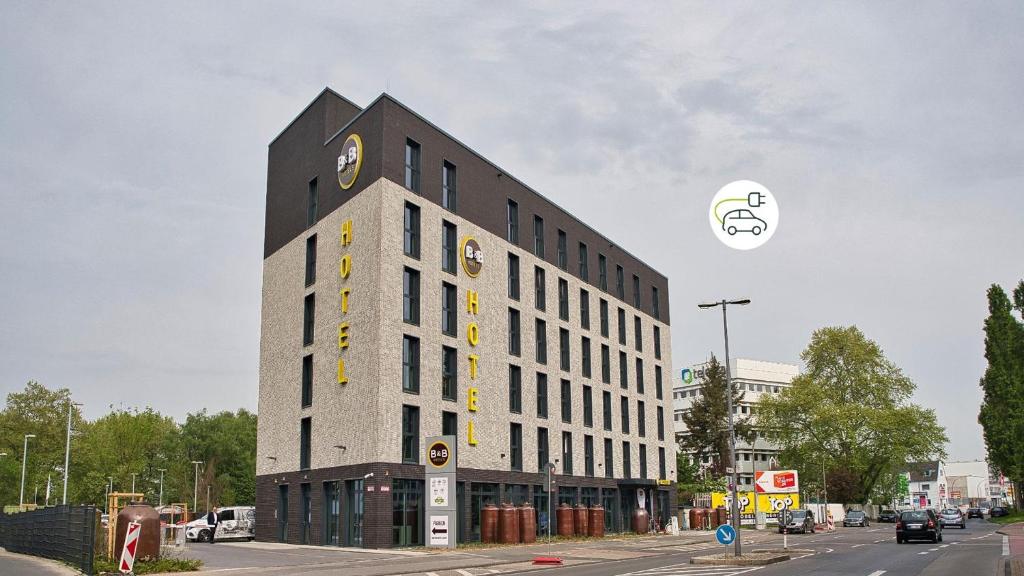 科隆B&B Hotel Köln-City的一座高大的建筑,旁边是钟