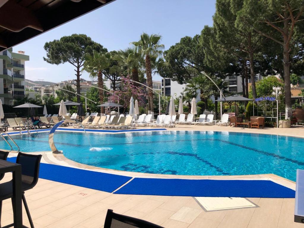 库萨达斯欧普斯公寓酒店的一个带椅子和遮阳伞的大型游泳池