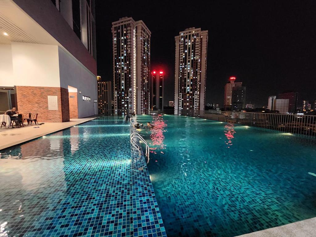 吉隆坡Chambers Residences Suites KLCC的一座晚上拥有城市天际线的游泳池