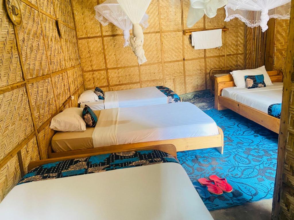 KibuyeKivu Macheo eco-lodge的一间房间,里面装有两张床和两双红色的鞋