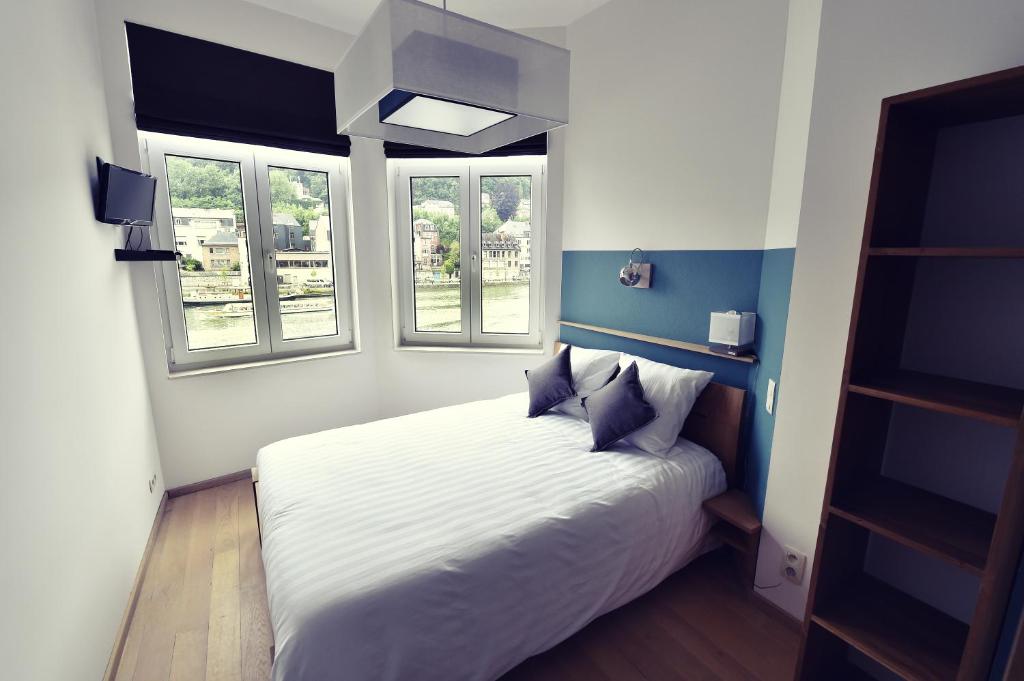 迪南考特萨克斯住宿加早餐旅馆的卧室配有白色的床和2扇窗户。