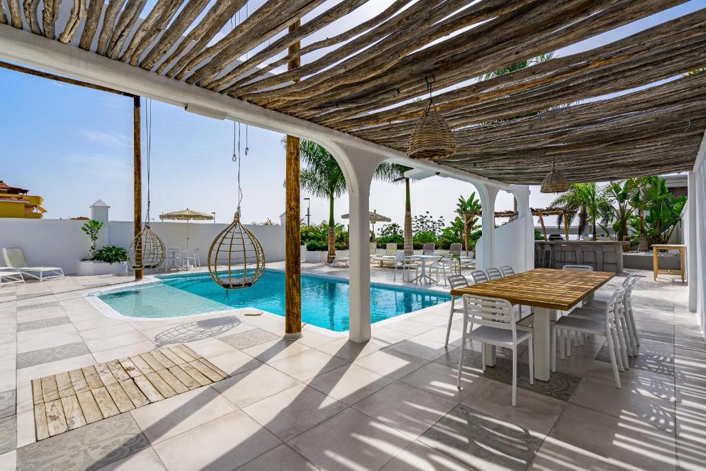 圣地亚哥港VILLA8的一个带桌椅的庭院和一个游泳池