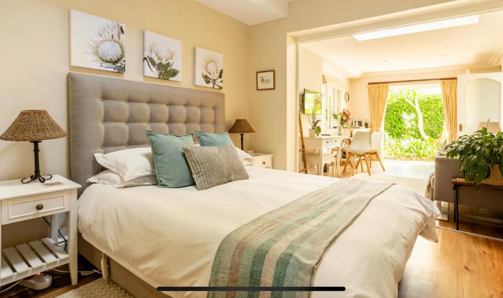 开普敦Guest suite - Leafy Constantia Guest House的一间带大床的卧室和一间餐厅