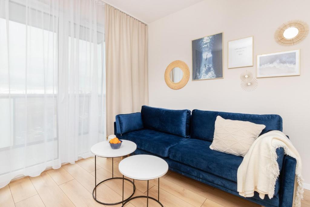 格但斯克Apartment Sucha Nowa Letnica by Renters的客厅配有蓝色的沙发和桌子