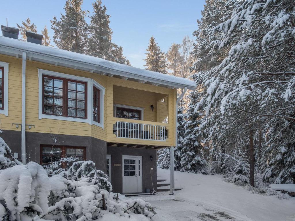 拉赫登佩拉Holiday Home Vaarapirtti - tähti by Interhome的雪中带阳台的黄色房子