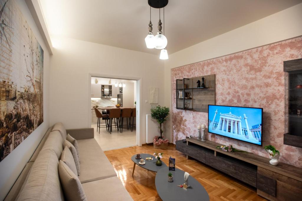 雅典Blue Ark Acropolis Compass的客厅配有沙发和墙上的电视