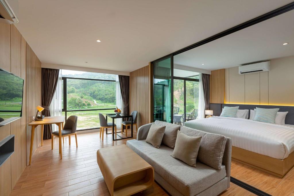 奈通海滩Wyndham Garden Naithon Phuket的一间卧室配有一张大床和一张沙发