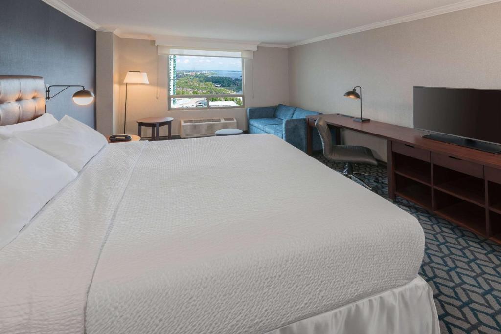 尼亚加拉瀑布Wyndham Fallsview Hotel的酒店客房设有一张大床和一张书桌。