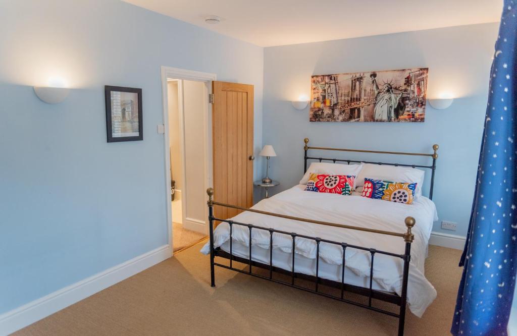 灵顿Stunning period cottage的卧室配有一张床,墙上挂有绘画作品