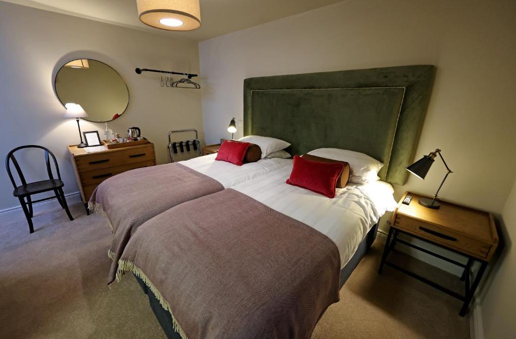 GlenoeSixty Six的一间卧室配有一张大床和两个红色枕头