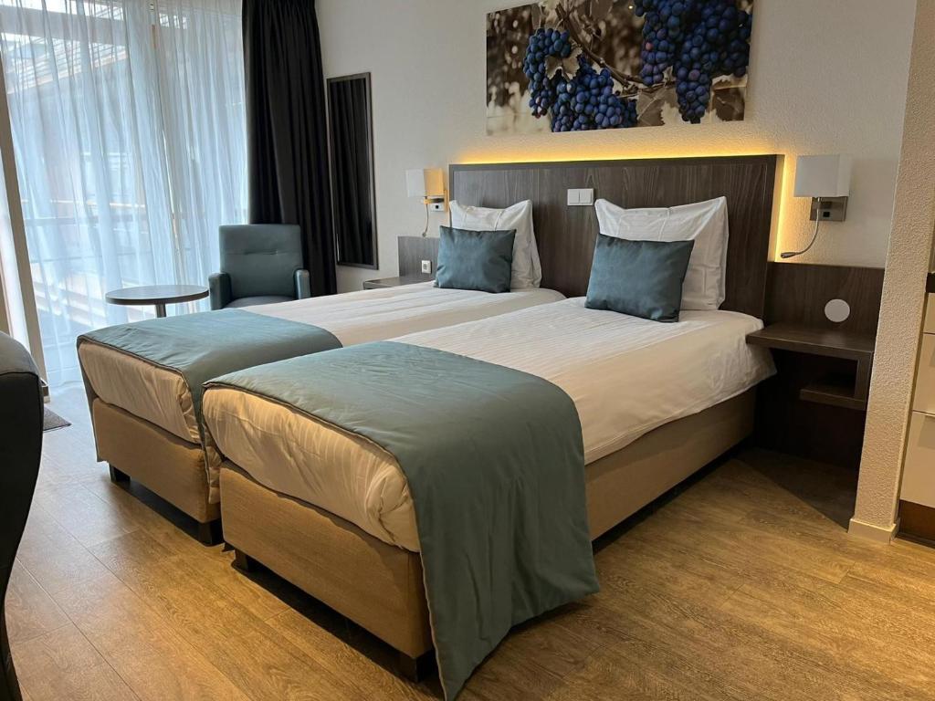 Beneden-Leeuwen林登酒店的一间位于酒店客房内的带两张床的卧室