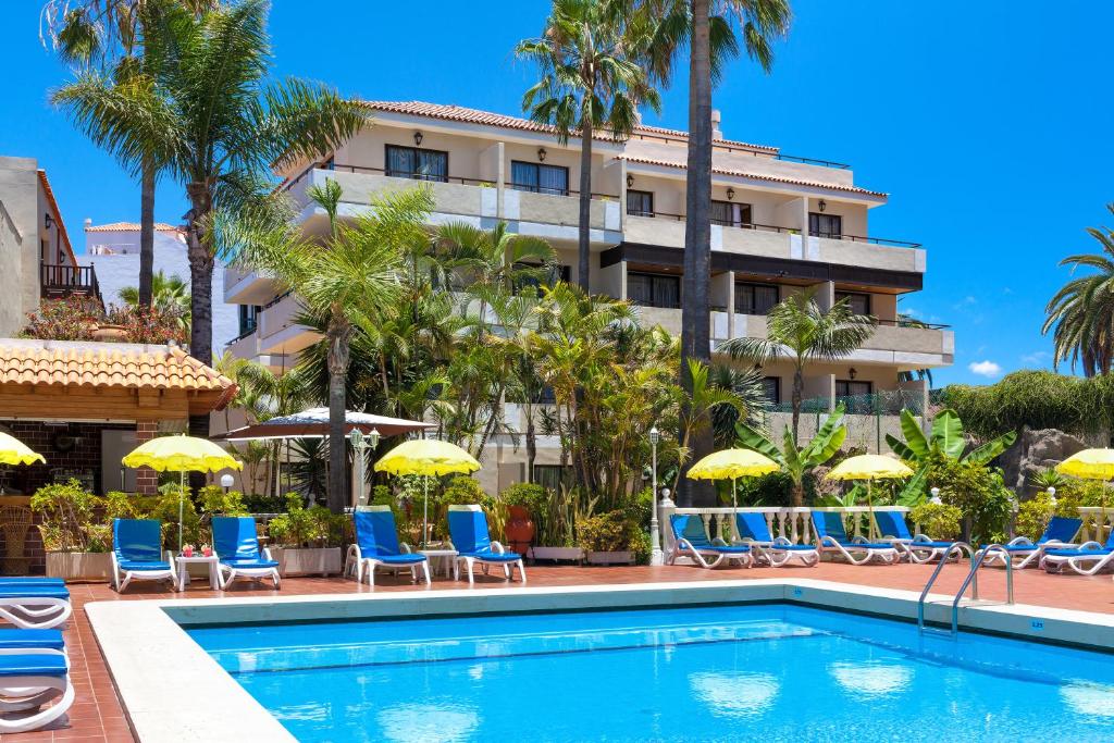 拉克鲁斯唐玛诺利透酒店的酒店设有带椅子和遮阳伞的游泳池