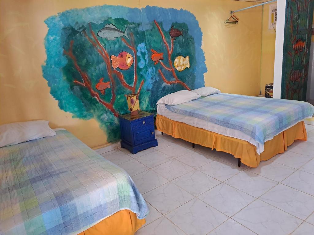 波托韦洛Villa Bella的一间设有两张床的客房,墙上挂着一幅画