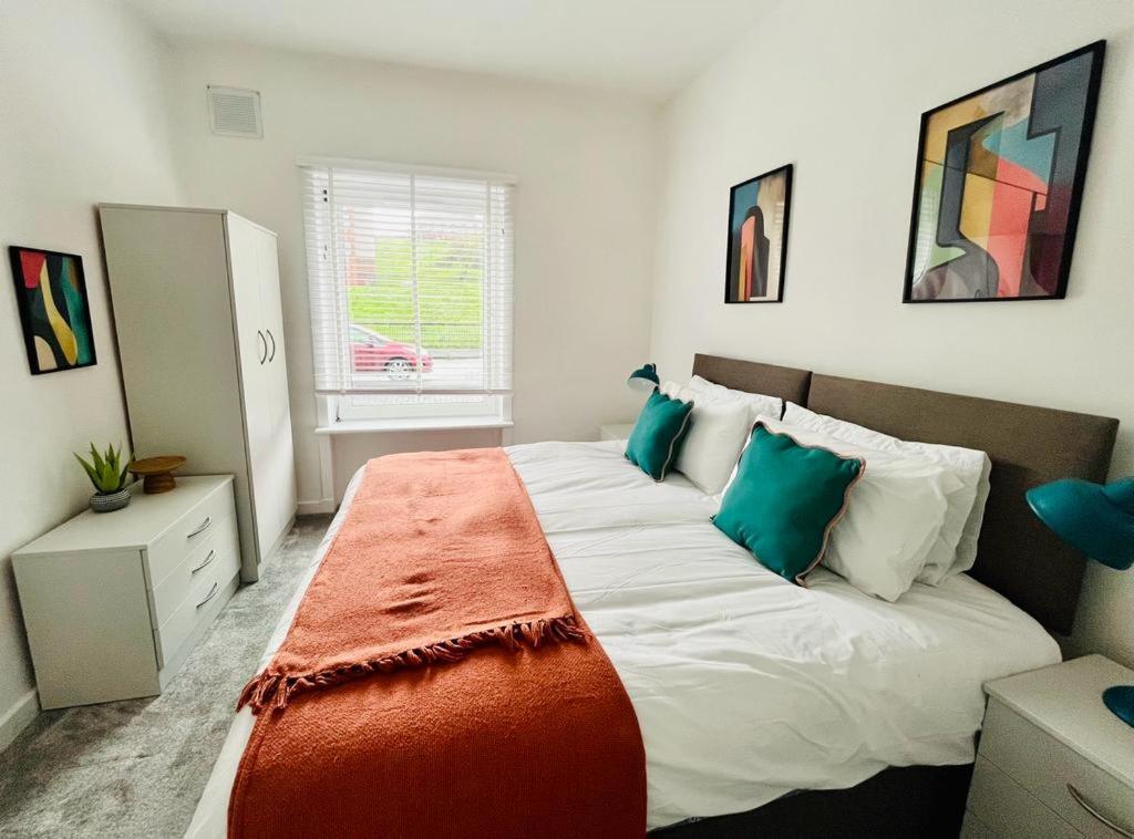 格拉斯哥Clyde 52的一间卧室配有一张带绿色枕头的大床