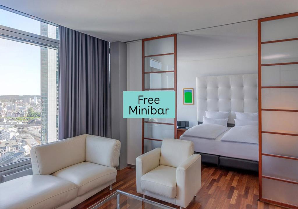美因河畔法兰克福INNSiDE by Meliá Frankfurt Eurotheum的酒店客房,配有两张床和两把椅子