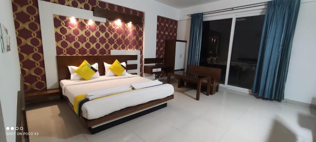 班加罗尔Suite Rooms Bellandhuru的一间卧室设有一张大床和一个大窗户
