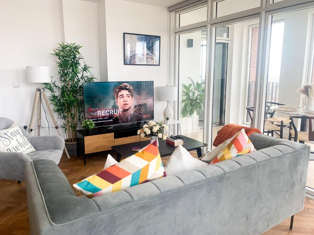 伦敦Luxurious two-bedroom flat with scenic views的客厅配有灰色沙发和电视