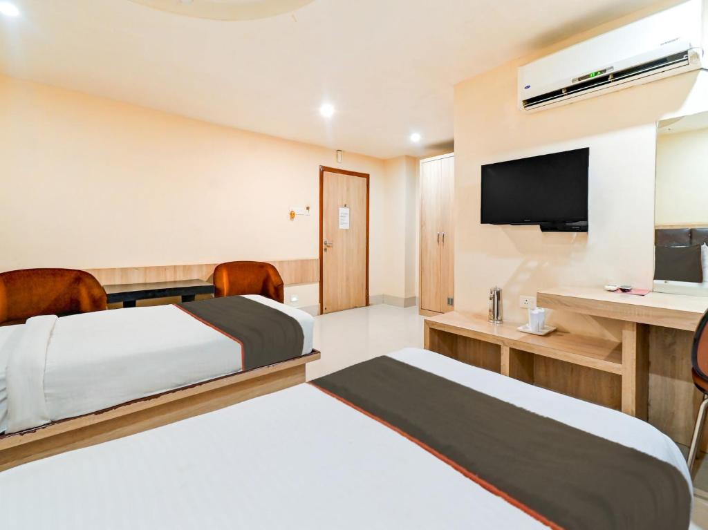 古瓦哈提Hotel Royal Heritage的酒店客房设有两张床和一台平面电视。
