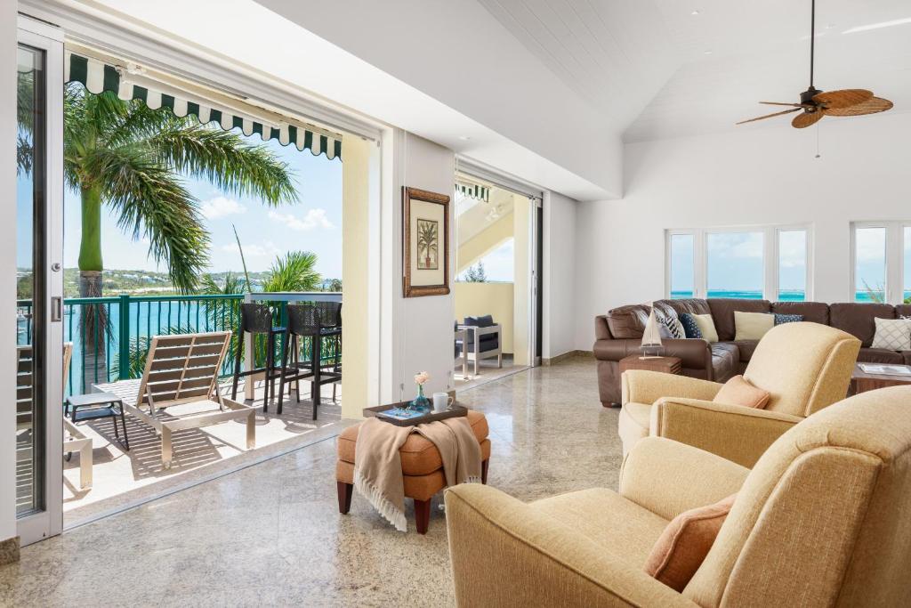 Turtle CoveThe Yacht Club Penthouse C14的带沙发和椅子的客厅以及阳台。