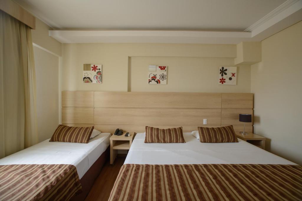 阿蒂巴亚Faro Hotel Atibaia的酒店客房配有两张床和一张书桌
