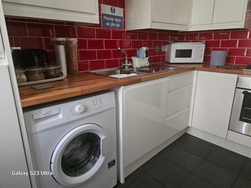 普里茅斯A Home From Home 3的厨房配有洗衣机和水槽