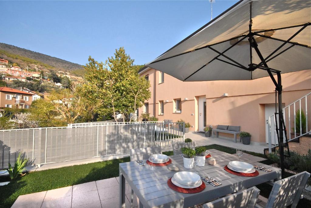 的里雅斯特Casa Vacanze Barcola的一个带桌子和遮阳伞的庭院