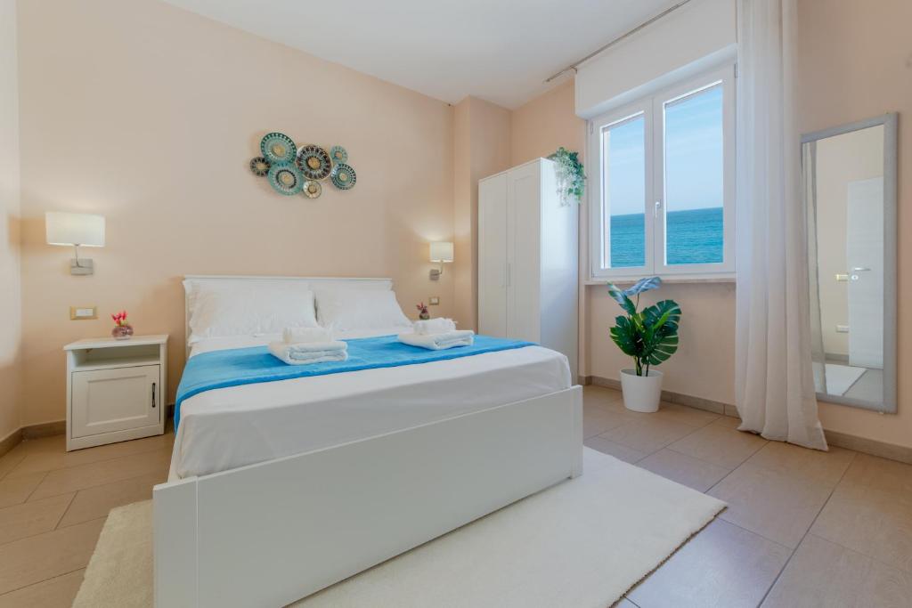 加利波利L'Affaccio Rooms - Lungomare Gallipoli的白色的卧室设有床和窗户